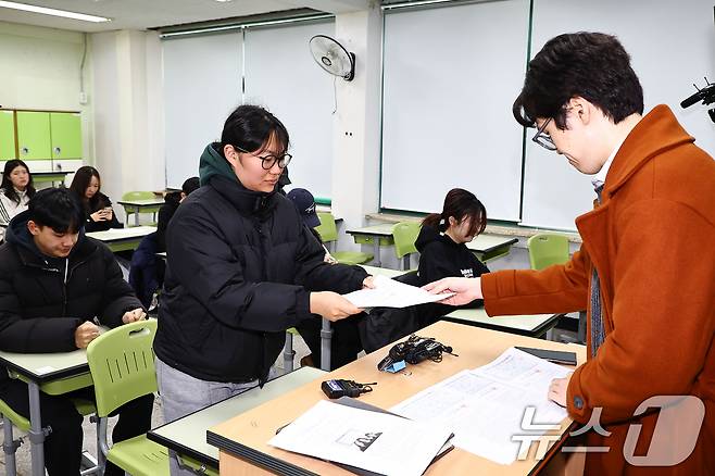 2025학년도 대학수학능력시험 성적표가 배부된 5일 오전 서울 광진구 광남고등학교에서 고3 수험생들이 담임선생님으로부터 수능 성적표를 받고 있다. (공동취재) 2025.12.5/뉴스1 ⓒ News1 오대일 기자