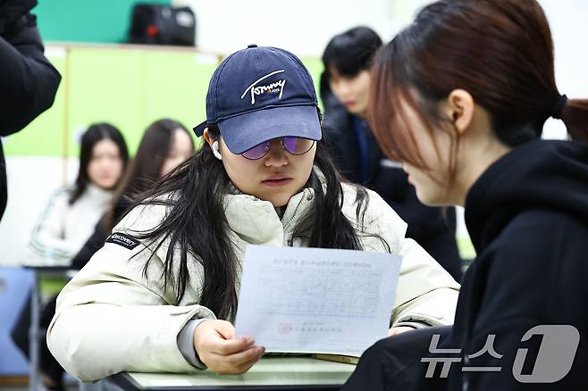 2025학년도 대학수학능력시험 성적표가 배부된 5일 오전 서울 광진구 광남고등학교에서 수능 성적표를 받은 고3 수험생들이 자신의 점수를 확인하고 있다. (공동취재) 2025.12.5/뉴스1 ⓒ News1 오대일 기자