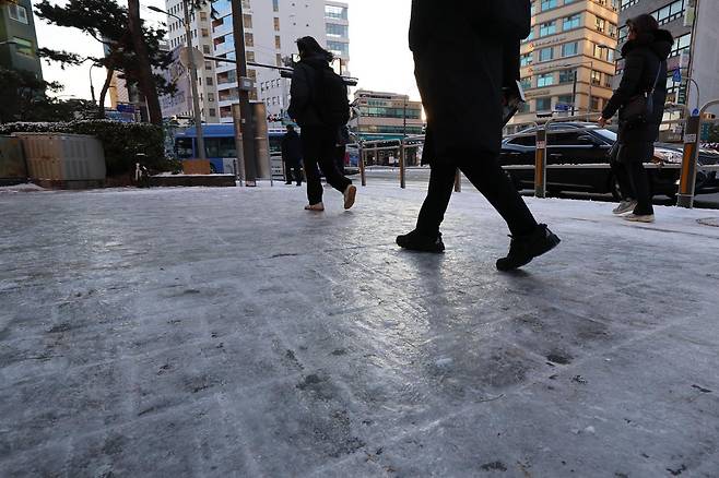 폭설 후 한파로 도로 곳곳이 얼어붙은 5일 오전 서울 중구 충무로역 인근에서 시민들이 빙판길을 조심히 걷고 있다. 뉴시스