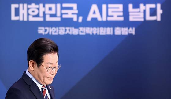 President Lee Jae Myung heads back to his seat after delivering remarks at the launch ceremony of the National Artificial Intelligence Strategy Committee held at Seoul Square in central Seoul on Sept. 8. The backdrop displays the slogan “Korea, Taking Flight with AI.” [YONHAP]