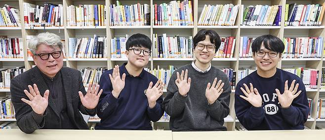 2026학년도 대학수학능력시험(수능) 성적표가 배부된 5일 서울 광진구 광남고등학교에서 수능 만점을 받은 왕정건 군이 취재진과의 인터뷰에서 기념사진을 찍고 있다. 왼쪽부터 최재일 광남고등학교 교장, 왕정건 군, 고무성 담임선생님, 서장협 씨