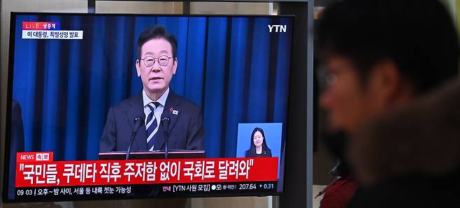 지난 3일 오전 서울 용산구 서울역 대합실에서 시민들이 이재명 대통령의 빛의 혁명 1주년 대국민 특별성명 생중계를 시청하고 있다. 임세준 기자