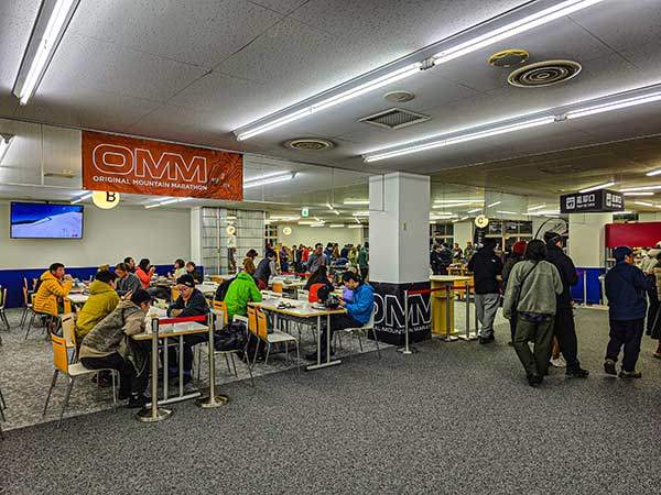 OMM 전야제. 스키장 리조트 건물 안에 참가자와 스태프가 모여 밥을 먹거나 업체 부스에서 필요한 장비를 구입한다.