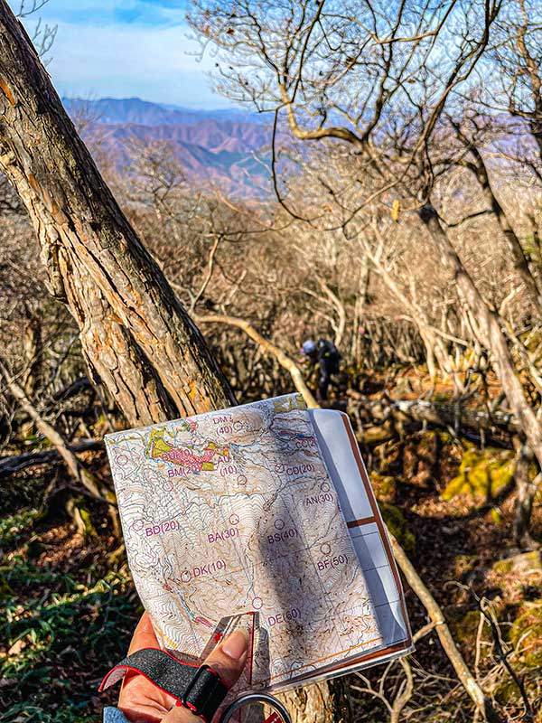  길이 없는 곳에서 지도와 나침반을 이용해 컨트롤을 찾고 있다.