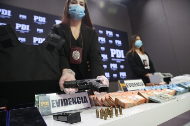 중국 마피아 조직원으로부터 압수한 총기류 들어 보이는 칠레 수사관. 칠레 수사경찰 엑스(X) 캡처.