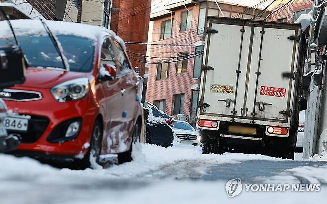 빙판길 작전상 후퇴 (서울=연합뉴스) 한종찬 기자 =  폭설 후 한파로 도로 곳곳이 얼어붙은 5일 서울 보광동 인근에서 트럭이 언덕길을 피해 후진하고 있다. 2025.12.5 saba@yna.co.kr