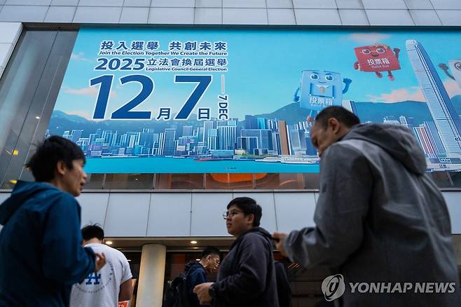 홍콩 입법회(의회) 선거 홍보 배너 앞을 지나가는 시민들 [AP=연합뉴스]