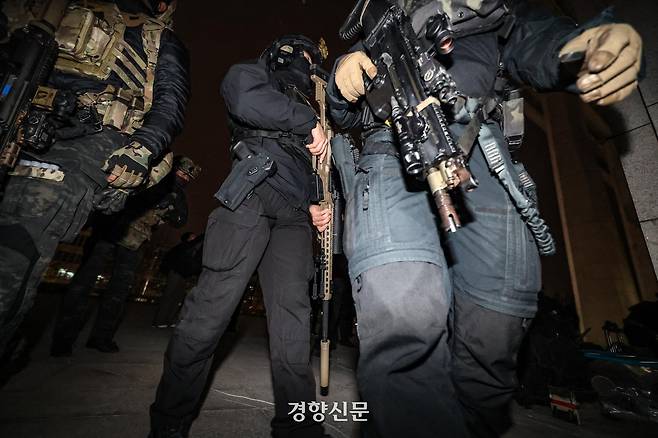 지난해 12월4일 새벽 국회에 투입된 계엄군들 사이에서 저격소총으로 무장한 군인이 국회 본청으로 향하고 있다. 성동훈 기자