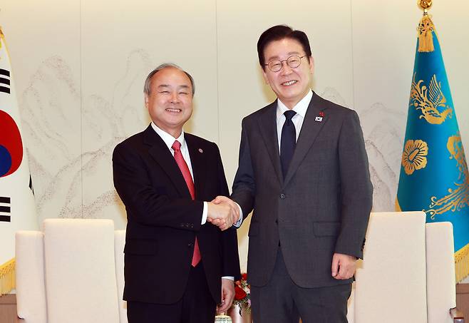 President Lee Jae Myung (right) shakes hands with Masayoshi Son, founder and CEO of SoftBank Group, at the presidential office in Yongsan-gu, central Seoul, Friday. (Joint Press Corps via Yonhap)