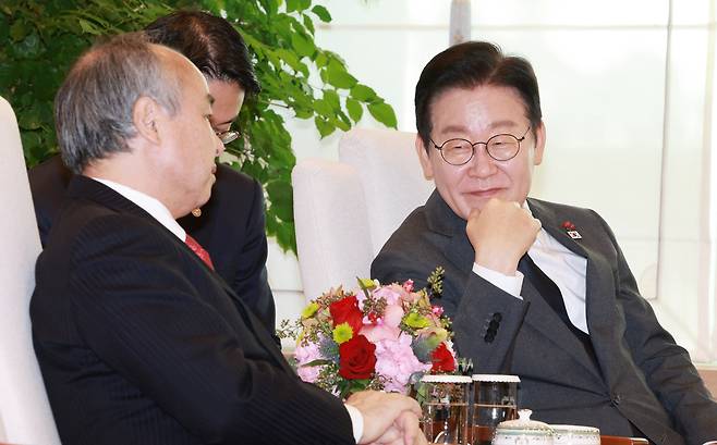Masayoshi Son (left), founder and CEO of SoftBank Group, speaks with President Lee Jae Myung at the presidential office in Yongsan-gu, central Seoul, Friday. (Joint Press Corps via Yonhap)