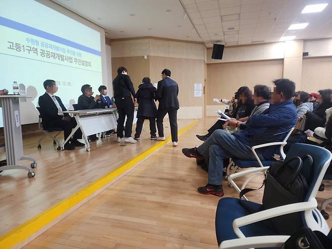 지난 5일 고등동 행정복지센터에서 열린 고등1구역 공공재개발사업 주민설명회에서 반대측 주민이 단상에 나와 수원도시공사 관계자 등에게 항의를 하던 중 제지를 당했다. 이시모 기자 simo@kihoilbo.co.kr