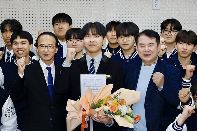 2026학년도 수능에서 만점을 받은 광주 서석고등학교 최장우(가운데)군이 지난 5일 이정선(오른쪽) 시교육감과 기쁨을 함께하며 파이팅을 외치고 있다.<광주시교육청 제공>