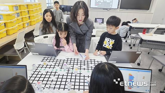 개포초등학교 3학년 학생들이 '재미있는 AI 로봇 실습 수업'에서 로봇 경로를 코딩하고 있다.