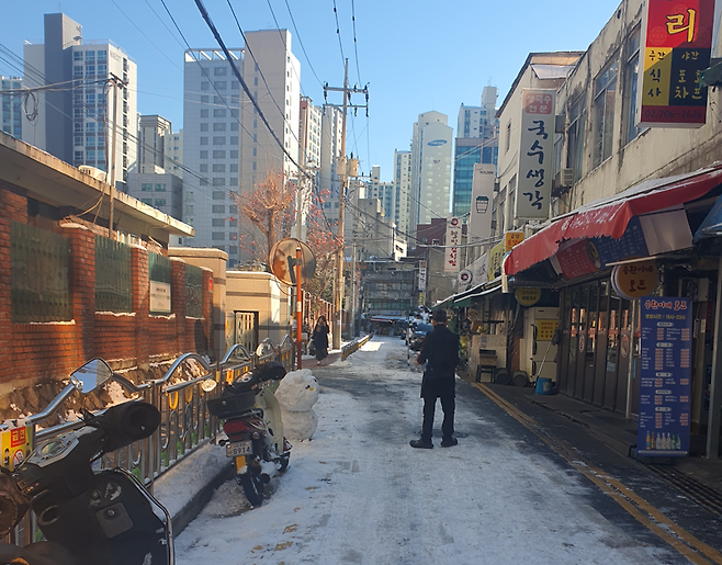 서울에 첫눈이 내린 다음 날인 지난 5일 오전 마포구 공덕시장 골목에서 한 상인이 눈을 치우고 남은 눈으로 눈사람을 만들었다. 사진=최승한 기자
