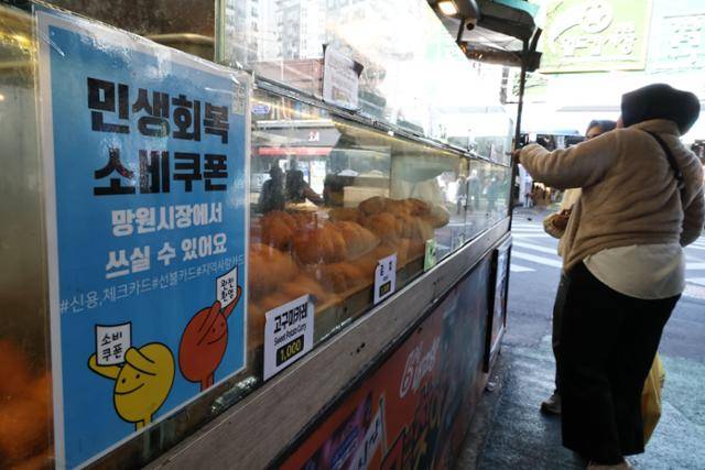 이달 1일 서울 마포구 망원시장 상점에 붙은 민생회복 소비쿠폰 안내문 모습. 연합뉴스