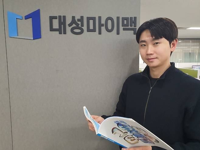 한정훈 대리가 대성마이맥 로고 앞에서 사회 교재를 보고 있다. 윤현주 기자
