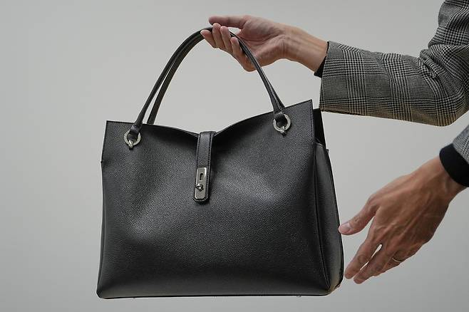 다카이치 총리가 지난 10월 21일 취임 후 처음 관저에 입성할 때 들었던 검은색 토트백. 145년 전통의 일본 브랜드 ‘하마노피혁공업’이 30년 전부터 판매해 온 ‘그레이스 딜라이트 토트백’이다.  [AP]