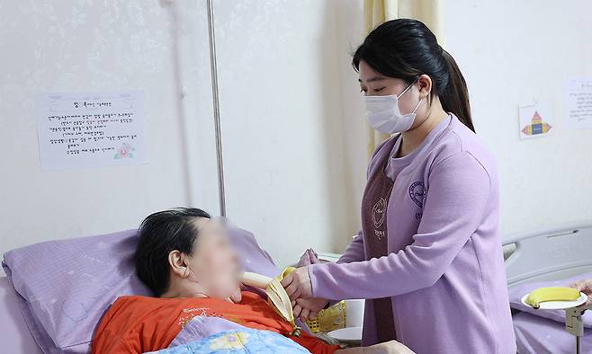 외국인 유학생 요양보호사 부티늉이 지난달 11일 경기 용인의 한 노인요양시설에서 한 노인이 간식을 먹는 것을 돕고 있다. 용인=남정탁 기자