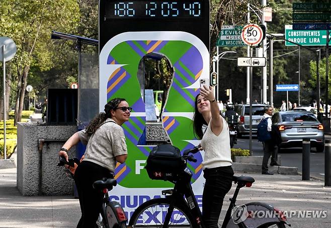 5일(현지시간) 멕시코시티에 있는 월드컵 홍보물에서 사진 찍는 주민 [멕시코시티 AFP=연합뉴스. 재판매 및 DB 금지]