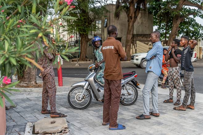 7일 쿠데타 직후 베냉 수도 코토누에 있는 라디오와 텔레비전 전파소 근처에서 한 무리 남자들이 담소를 나누고 있다. /연합뉴스