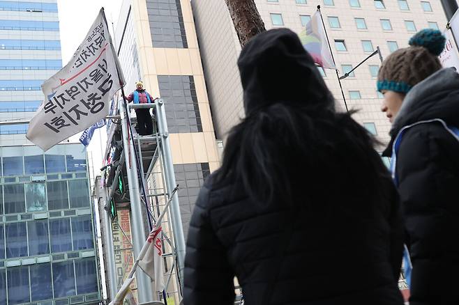 정리해고 철회를 촉구하며 고공농성중인 세종호텔 해고노동자 고진수씨가 지난달 24일 아침 서울 중구 세종호텔 앞 교통구조물 위에서 아침 식사를 받은 뒤 연대 동지들과 아침 인사를 나누고 있다. 백소아 기자 thanks@hani.co.kr