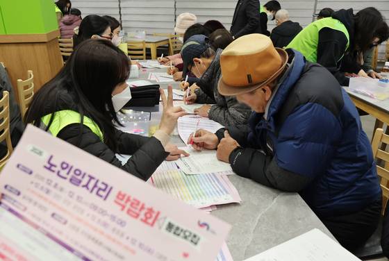 8일 오전 부산 남구청에서 열린 '부산 남구 2026 노인 일자리 박람회'에서 구직을 희망하는 어르신들이 직원의 도움을 받아 신청서를 작성하고 있다.   연합뉴스