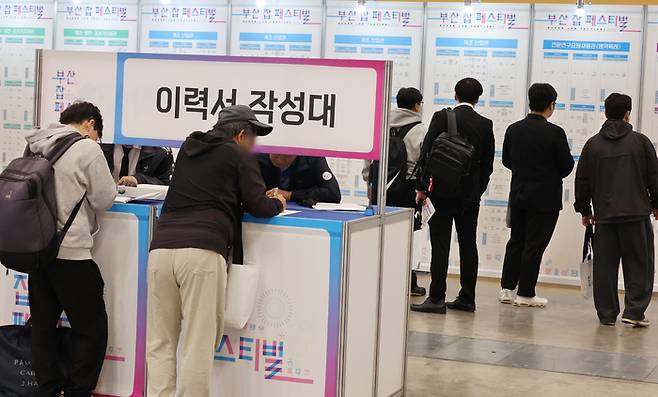 지난 10월 부산 해운대구 벡스코 제1전시장에서 열린 ‘2025 부산 잡(JOB) 페스티벌’에서 구직자들이 채용기업 현황판을 살펴보고 있다. [연합뉴스]