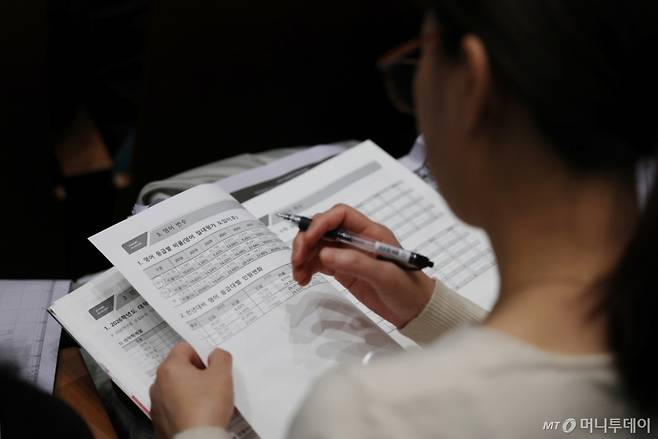 7일 서울 종로구 성균관대학교 600주년 기념관에서 열린 종로학원 주최 '2026 정시 합격 가능선 예측 및 지원전략 설명회'에서 참석자가 자료를 살펴보고 있다. /사진=뉴시스