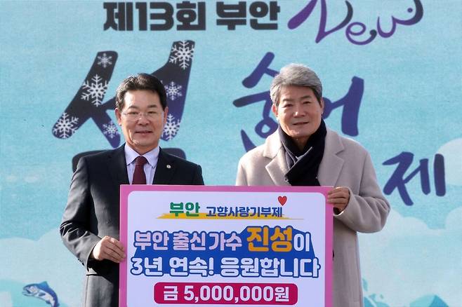 트로트 가수 진성(오른쪽)이 지난 5일 열린 제13회 부안군 설숭어축제장을 찾아 고향사랑기부금 500만원을 권익현 부안군수에게 기탁하고 있다. 부안군 제공