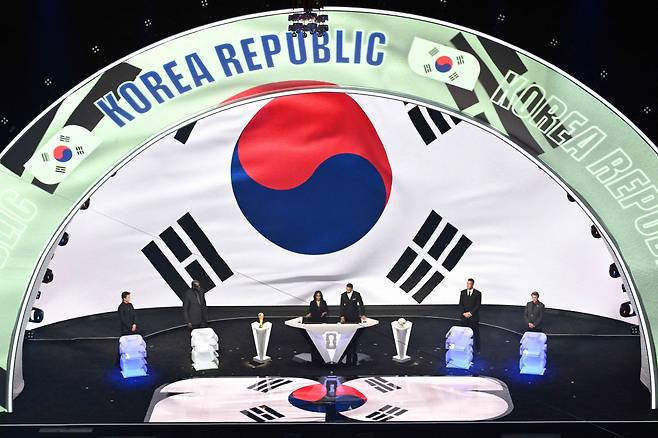 지난 6일 미국 워싱턴 DC 케네디센터에서 열린 2026 북중미 월드컵 조 추첨식에서 한국이 뽑힌 뒤, A조에 배정되면서 구체적인 조별리그 일정이 전광판(아래 작은 사진)을 통해 소개되고 있다. 워싱턴DC | AFP·로이터연합뉴스