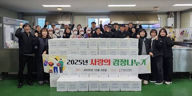 ▲ 5일 의성시니어클럽 조리실에서 김성진 관장(뒷줄 중앙)이 직원·참여 어르신들과 함께 완성한 김장 박스를 정면에 쌓아두고 주먹을 들어 올리며 나눔 준비를 마친 순간을 기념하고 있다. 의성군
