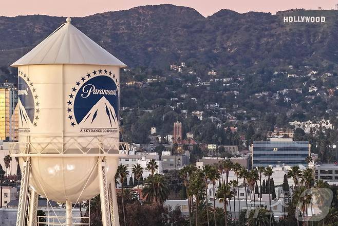 8일(현지시간0 캘리포니아주 로스앤젤레스에서 할리우드 간판을 배경으로 촬영된 파라마운트 스튜디오 내 워터 타워가 보인다. 2025.12.8 ⓒ AFP=뉴스1