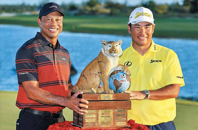 히어로 월드 챌린지 우승자 마쓰야마 히데키(오른쪽)가 8일 대회를 주최한 타이거 우즈와 트로피를 사이에 두고 기념 촬영을 하고 있다./AFP 연합뉴스