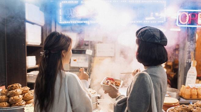 야시장 먹거리 앞에 선 외국인 관광객들, 실제 체류형 미식 경험으로 확장되는 순간. (제주관광공사 제공)