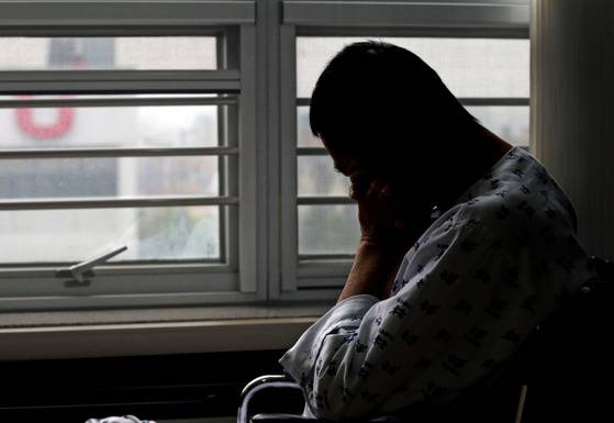 병원 창가에 앉아서 바닥을 내려다보고 있는 입원 환자. [중앙포토]