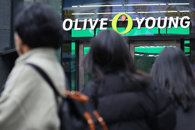 People are seen passing by an Olive Young store in Seoul on March 12. [YONHAP]