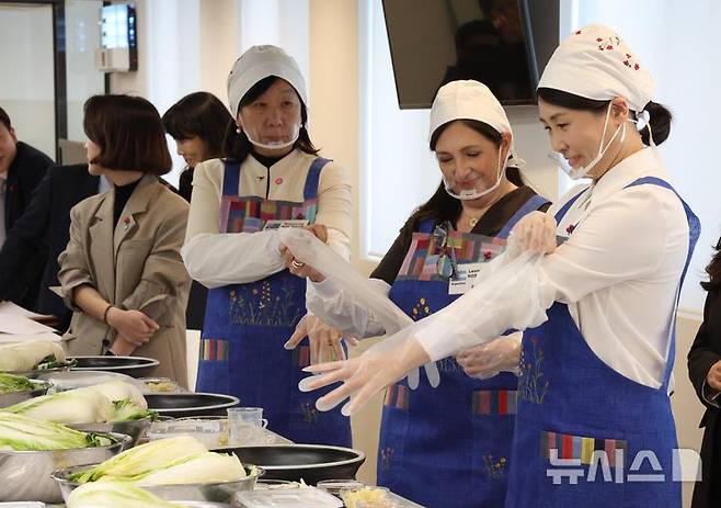 [서울=뉴시스] 고범준 기자 = 김혜경 여사가 9일 서울 종로구 북촌 한식문화공간 이음에서 열린 주한대사 배우자 초청 김장 행사에서 장갑을 착용하고 있다. 2025.12.09. bjko@newsis.com