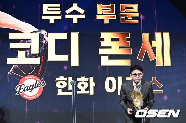 [OSEN=조은정 기자] 9일 오후 서울 송파구 잠실동 롯데호텔 월드에서 2025 신한은행 SOL 뱅크 KBO 골든글러브 시상식이 열렸다.KBO 골든글러브 시상식은 포지션별 최고의 선수를 가리는 자리로 올 시즌의 대미를 장식하는 자리다.&nbsp;한화 손혁 단장이 투수 부문 수상한 한화 코디 폰세 대리 수상을 하고 있다. 2025.12.09 /cej@osen.co.kr