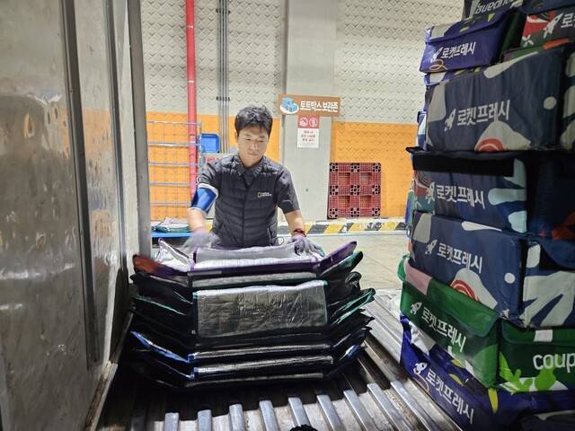 류석우 기자가 서울 장지동의 쿠팡 송파○캠프에서 회수한 프레시백을 정리하고 있다. 프레시백 안의 아이스팩과 쓰레기를 정리하는 일도 쿠팡 택배기사의 몫이다. 류석우 기자