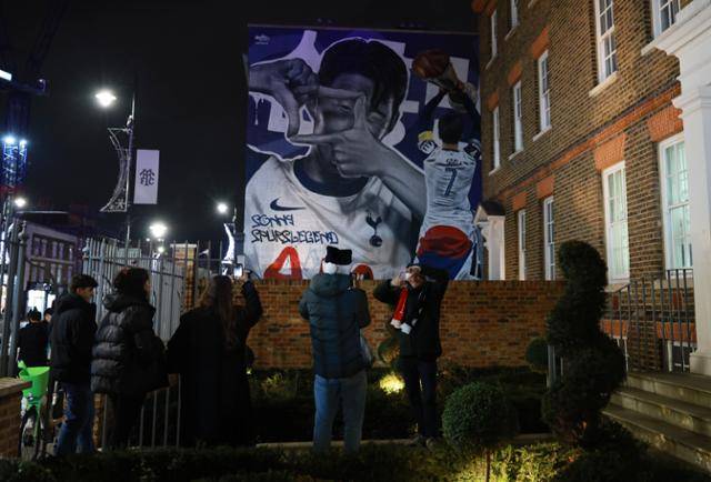 손흥민의 벽화가 그려진 건물 앞에서 팬들이 사진 촬영을 하고 있다. 런던=EPA 연합뉴스