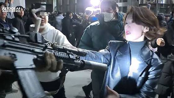지난해 12·3 비상계엄 당시 국회의사당에 진입한 계엄군의 총구를 붙잡은 안귀령 대통령실 부대변인 모습. 사진 JTBC 캡처