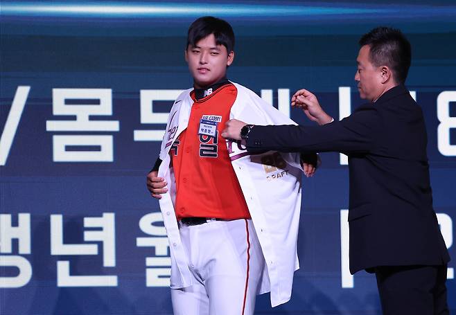 Park Jun-hyun, a right-handed pitcher from Bugil High School and the first overall pick in the first round, puts on his uniform after being selected by the Kiwoom Heroes during the 2026 KBO Rookie Draft at Lotte Hotel World in Songpa District, southern Seoul, on Sept. 17. [YONHAP]