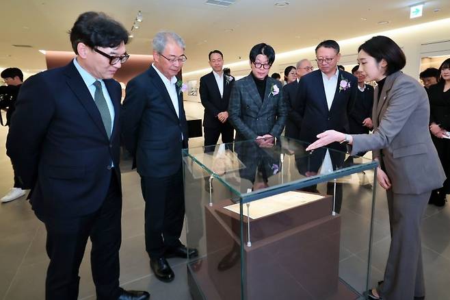 11일 임종룡 우리금융그룹 회장(앞줄 왼쪽 두번째부터), 고 박경리 작가 외손자 김세희 토지문화재단 이사장, 정진완 우리은행장이 서울 중구 '우리1899'에서 서울시 지정문화재인 '대한천일은행 창립청원서'에 대한 설명을 듣고 있다. 우리금융지주 제공