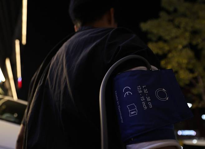 류석우 기자가 신체 변화 측정을 위해 착용한 24시간 활동혈압계. 커프는 팔에 착용했고, 단말기는 크로스백처럼 끈을 달아 어깨에 걸쳤다. 이종근 선임기자