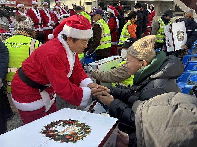 ‘사회적기업과 함께하는 몰래산타 이웃사랑 나눔행사’ 봉사자가 지난 9일 인천 게양구 사회적기업회관에서 선물을 전하고 악수하고 있다.
