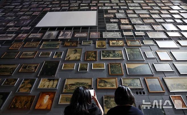 [부산=뉴시스] 하경민 기자 = 제80주년 광복절을 앞두고 지난 8월 11일 부산 남구 국립일제강제동원역사관에서 관람객들이 강제징용 피해자와 유족 등이 기증한 다양한 사진을 채운 벽면을 둘러보고 있다. 2025.12.11. yulnetphoto@newsis.com