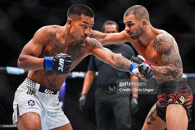 미얀마 소수 민족 출신 파이터 조슈아 반(왼쪽)이 지난 7일 UFC 플라이급 챔피언 타이틀전에서 알렉산드르 판토자와 주먹을 주고받고 있다. 이날 1라운드 26초 만에 TKO 승을 거둔 반은 “이 승리를 조국 미얀마에 바치겠다”고 했다./게티이미지코리아