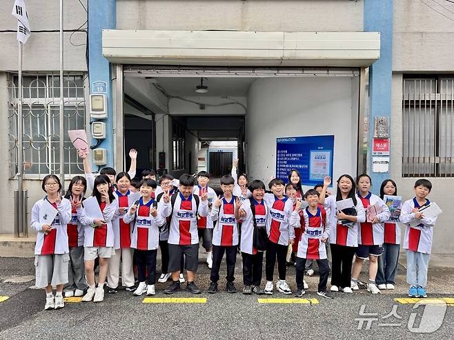 학생들이 영화 '학교정복' 홍보 티셔츠를 입고 현장체험 인증 사진에 포즈를 취하고 있다.(전남도교육청 제공, 재판매 및 DB 금지)/뉴스1