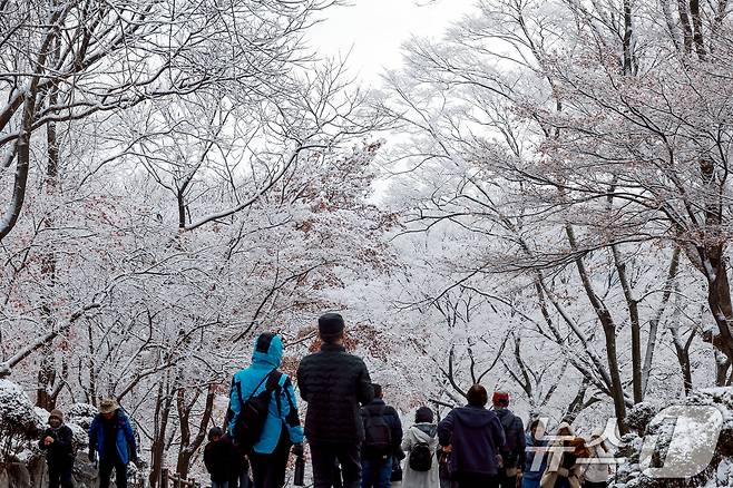 지난 밤 내린 눈이 쌓인 14일 서울 용산구 남산공원을 찾은 시민들이 겨울풍경을 만끽하고 있다. 2025.12.14/뉴스1 ⓒ News1 이호윤 기자