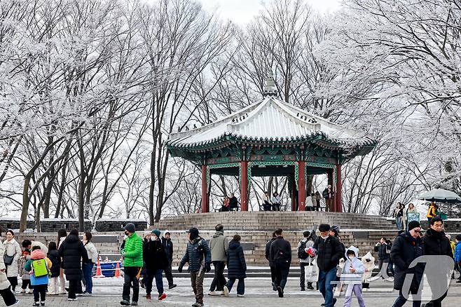 지난 밤 내린 눈이 쌓인 14일 서울 용산구 남산공원을 찾은 시민들이 겨울풍경을 만끽하고 있다. 2025.12.14/뉴스1 ⓒ News1 이호윤 기자